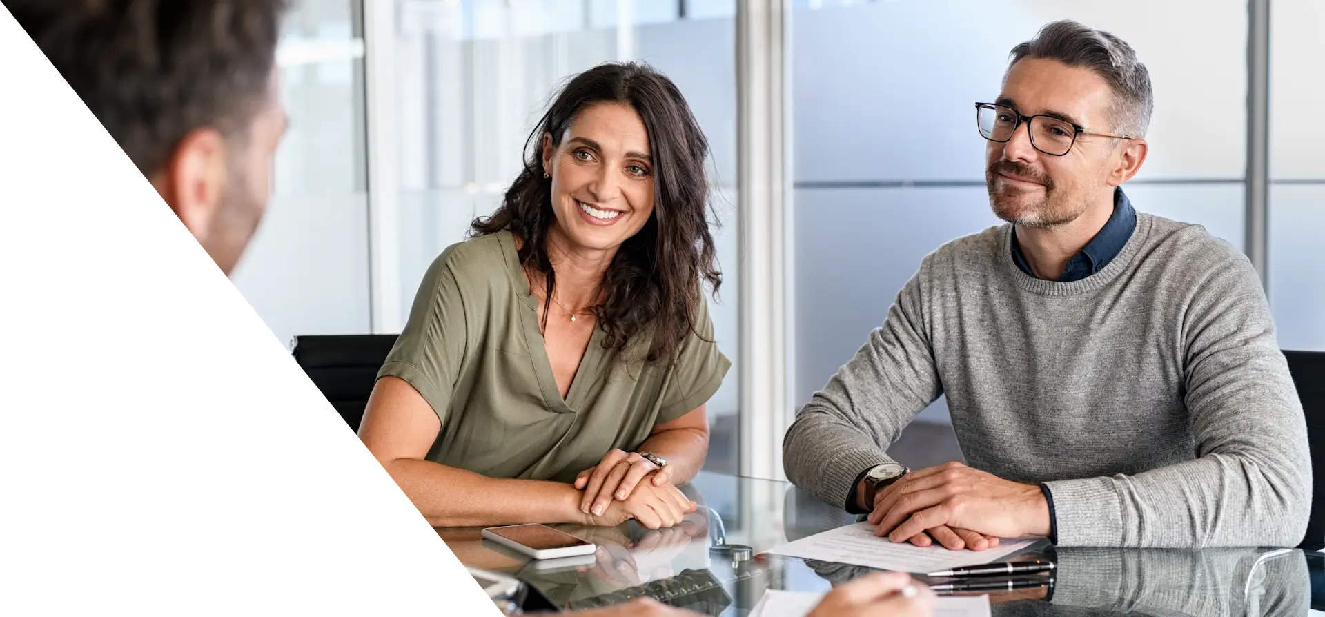 man and woman sitting at a table with papers 